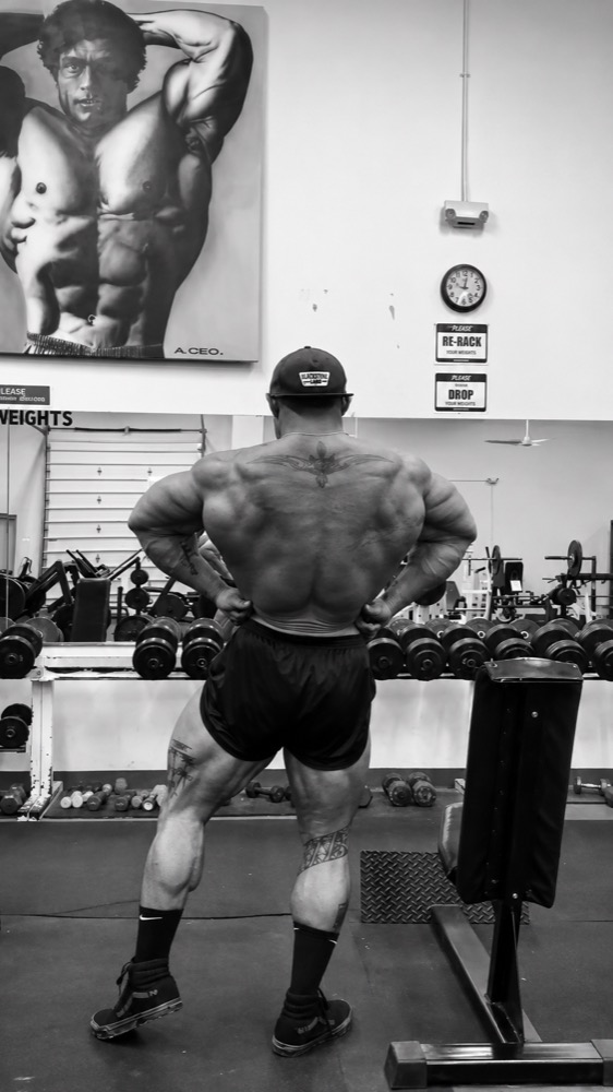 Nam Thomas Shartzer showing back muscular development in the gym